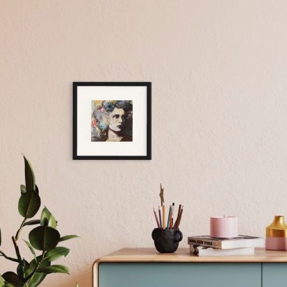 art print hanging on a wall above a plant and desk