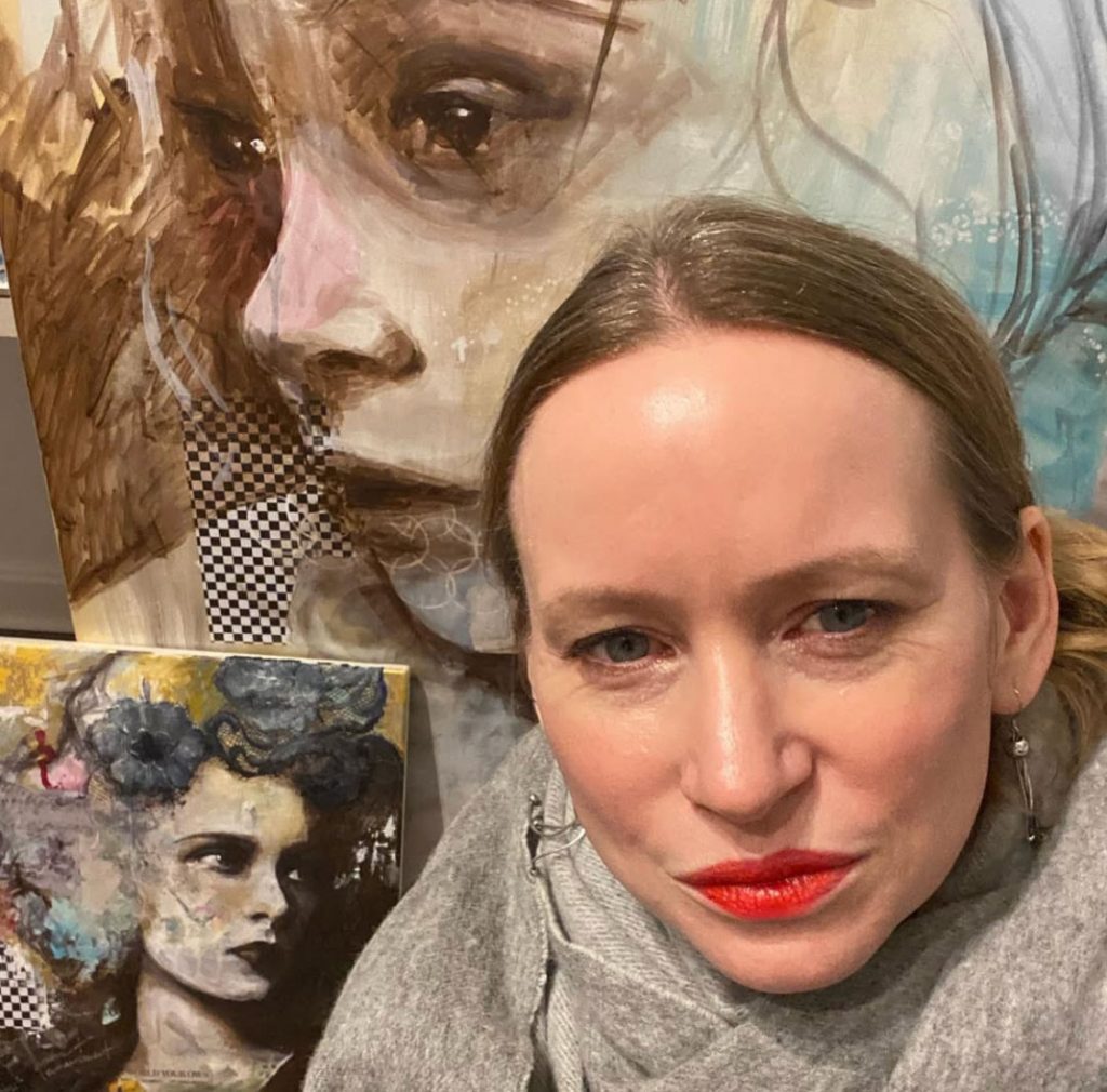 a woman with paintings in the background