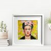 framed painting of Frida Kahlo on a shelf with plants
