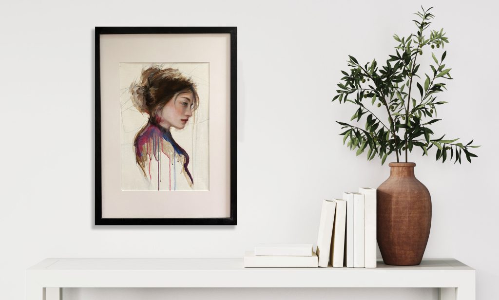 Oil painting in a frame on a white wall with vase, leaves and boosk